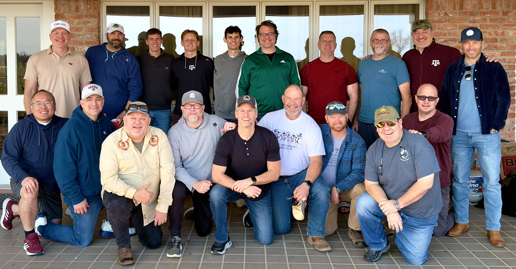 About twenty BYX alumni brothers gathered for a group photo, two rows, on a ranch porch