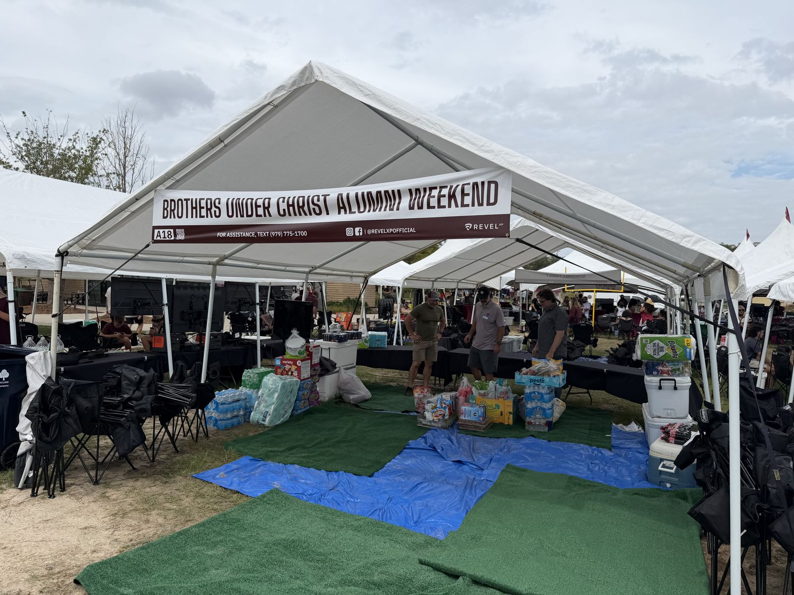The BYX tent at A18 with the Brothers Under Christ Alumni Weekend banner, before the crowd