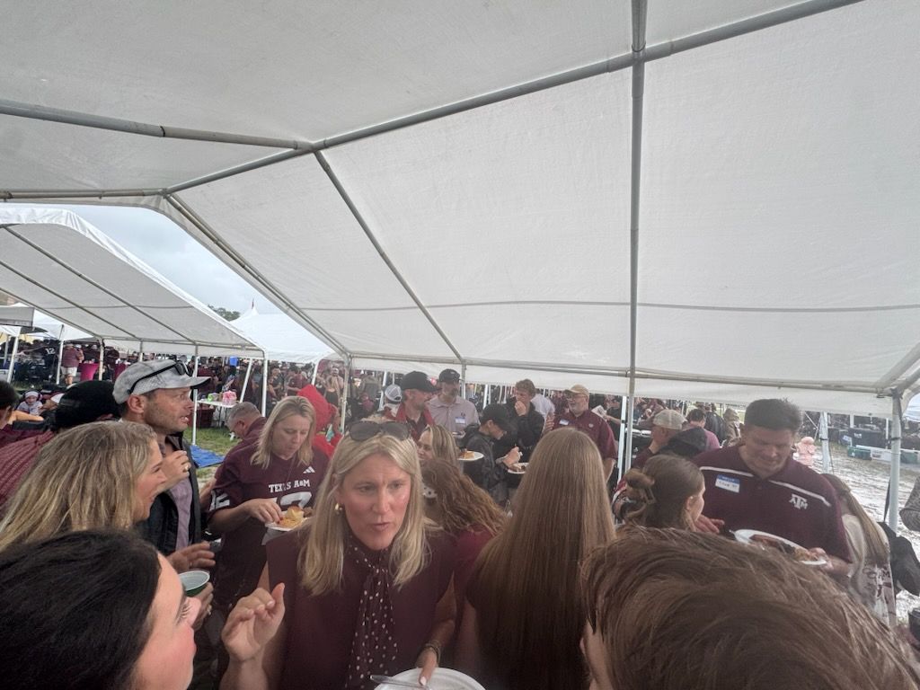 Wives and families filling plates under the tent